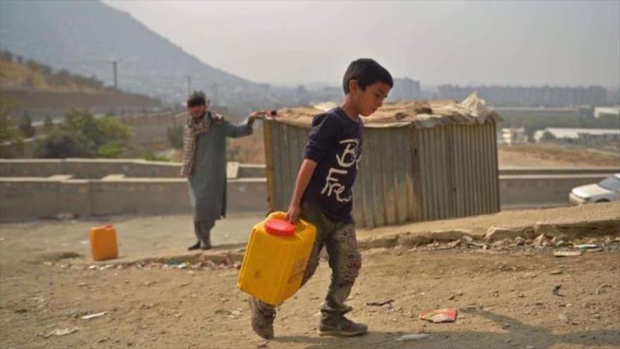Un niño lleva un recipiente de agua potable en Kabul, capital de Afganistán, 1 de octubre de 2021. (Foto: AFP)