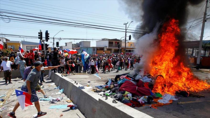 
Manifestantes queman las pertenencias de los migrantes venezolanos en un campamento en Iquique, Chile, el 25 de septiembre de 2021. (Foto: Reuters)
