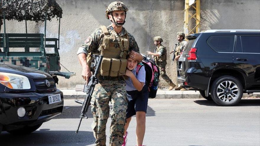 Un soldado libanés ayuda a una colegiala a llegar a sus padres, después de que estallara un tiroteo en Beirut, capital de El líbano, 14 de octubre de 2021. (Foto: Reuters)