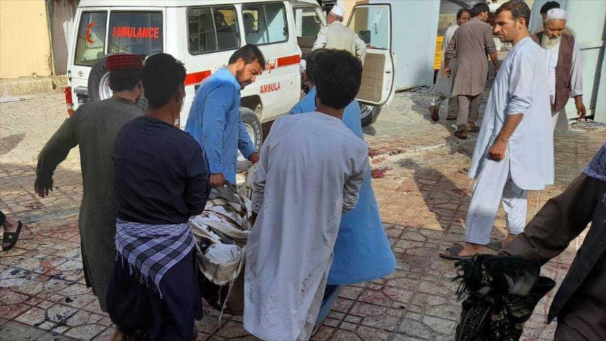 Lugareños llevan a un herido hacia la ambulancia tras una explosión en Kandahar, sur de Afganistán, 15 de octubre de 2021.