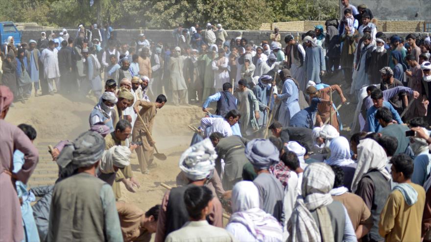 Ciudadanos afganos cubren con tierra las tumbas de las víctimas mortales de los ataques terroristas en Kandahar, 16 de octubre de 2021. (Foto: AFP)