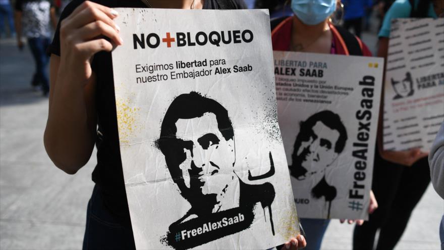 La gente sostiene carteles con la imagen de Alex Saab en una manifestación en Caracas, capital de Venezuela, para pedir su liberación, 17 de octubre de 2021. (Foto: AFP)