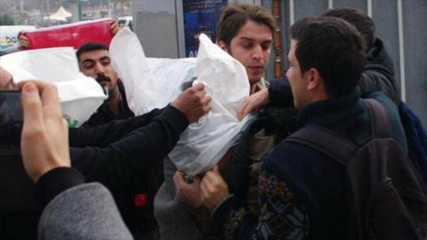 Los manifestantes turcos intentan poner una capucha sobre la cabeza de un empleado de la Marina estadounidense, 2 de noviembre de 2021.