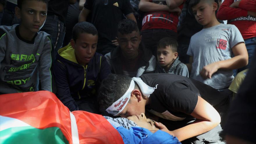 Amigos de joven palestino Muhamed Daadas se despiden por última vez en su funeral en Nablús, en ocupada Cisjordania, 6 de noviembre de 2021. (Foto: AFP)