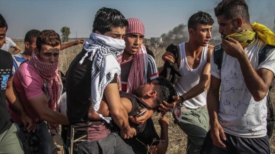 Jóvenes palestinos transfieren a un hombre que resultó herido como consecuencia de la brutal represión israelí de una protesta en Cisjordania. (Foto: Al Jazeera)