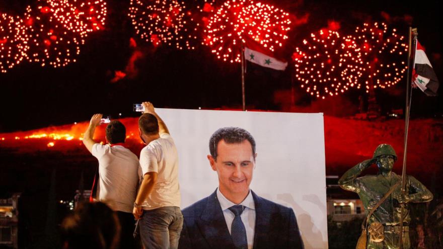 Una foto gigante del presidente de Siria, Bashar al-Asad, se ve mientras sus partidarios celebran su reelección, Damasco, 27 de mayo de 2021. (Foto: Reuters)