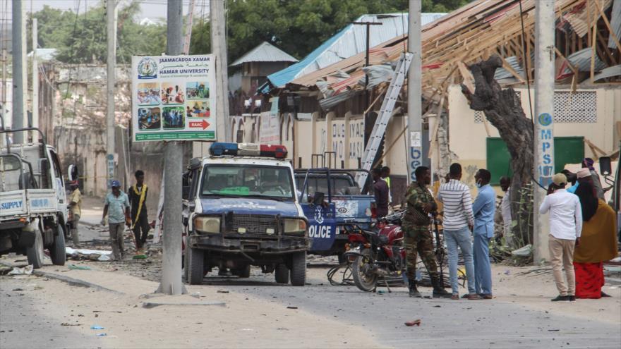 Agentes de Policía y personas se encuentran en el lugar de la explosión de la bomba en Mogadiscio, Somalia, 25 de noviembre de 2021.