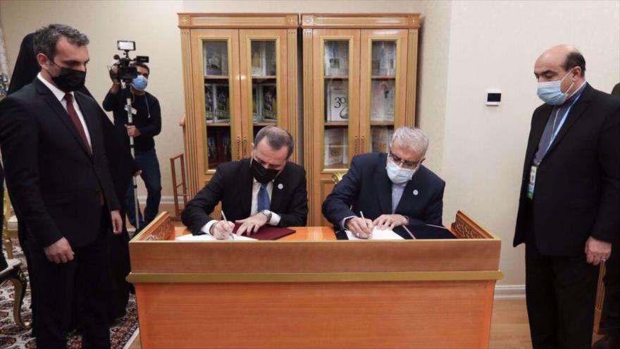 El ministro de Petróleo iraní, Yavad Oyi (dcha.) firma un acuerdo trilateral de intercambio de gas en Asjabad, capital turkmena, 28 de noviembre de 2021.