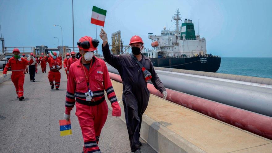 Trabajadores con banderas iraníes y venezolanas celebran la llegada del petrolero iraní “Fortune” a una refinería venezolana. (Foto: Getty Images)