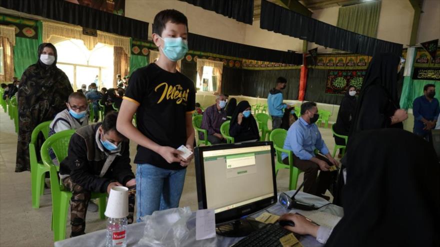 Un migrante adolescente afgano espera para recibir la vacuna anti-COVID-19 en un centro de vacunación en Irán.
