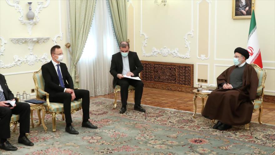 El presidente iraní, Seyed Ebrahim Raisi (dcha.), reunido con el canciller de Hungría, Péter Szijjártó (izda.), en Teherán, capital iraní, 16 de diciembre de 2021. (Foto: President.ir)