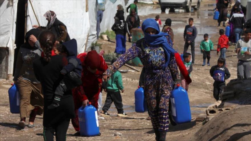 Los refugiados sirios caminan en un campamento de acogida en El Líbano, 12 de marzo de 2021. (Foto: Reuters)
