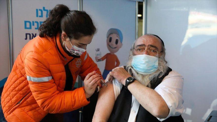 Un judío israelí recibe vacuna contra la COVID-19 en los territorios ocupados por Israel.
