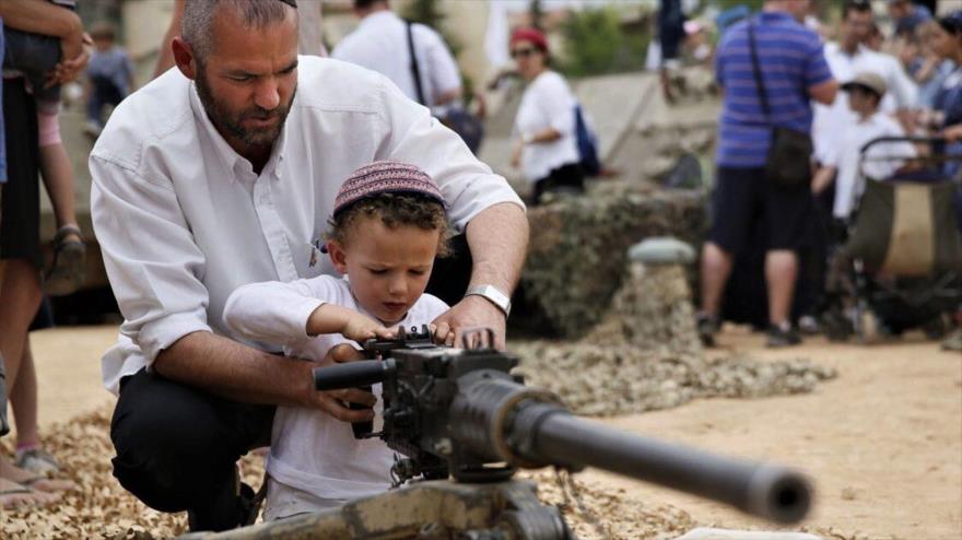 Un colono israelí muestra a su hijo cómo usar una ametralladora contra los palestinos en el asentamiento de Efrat en la ocupada Cisjordania.