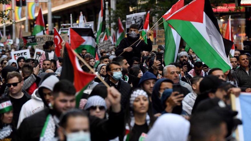 Manifestantes ondeando banderas palestinas durante una manifestación contra el régimen israelí en Sydney, 15 de mayo de 2021. (Foto: AFP)
