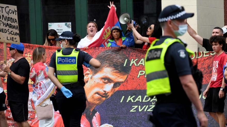 Miembros de la comunidad serbia se reúnen frente a un centro de detención donde el tenista Novak Djokovic, Melbourne, 9 de enero de 2022. (Foto: AFP)