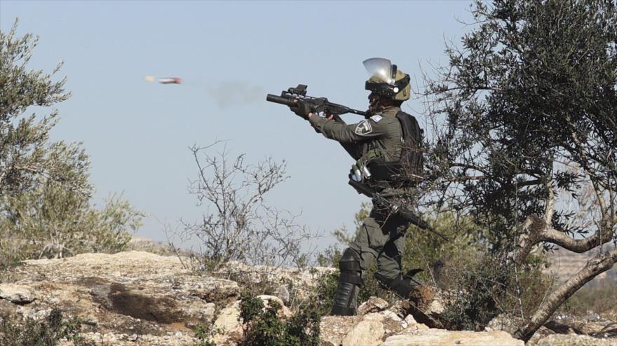 Un Soldado israelí lanza gases lacrimógenos en medio de enfrentamientos con manifestantes palestinos en la Cisjordania ocupada, 7 de enero de 2022. (Foto: AFP)