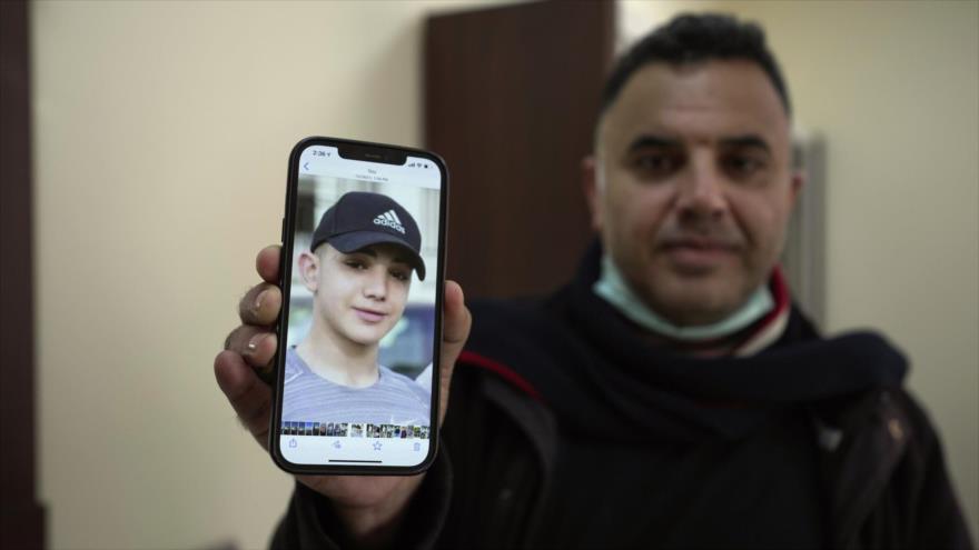 Muamar Najle, padre de Amal Najle, un adolescente palestino detenida sin cargos hace un año, muestra su foto, 10 de enero de 2022. (Foto: AP)
