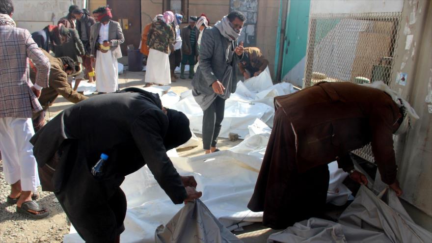 Yemeníes inspeccionan los cuerpos de las víctimas un día después de los ataques aéreos saudíes en Saada, norte de Yemen, 22 de enero de 2022. (Foto: AFP)