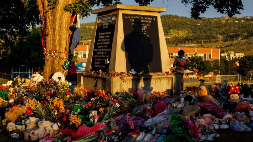 Monumento rodeado de flores en memoria de 215 niños muertos en la escuela residencial indígena de Kamloops, en Canadá, 5 de junio de 2021. (Foto: AFP)
