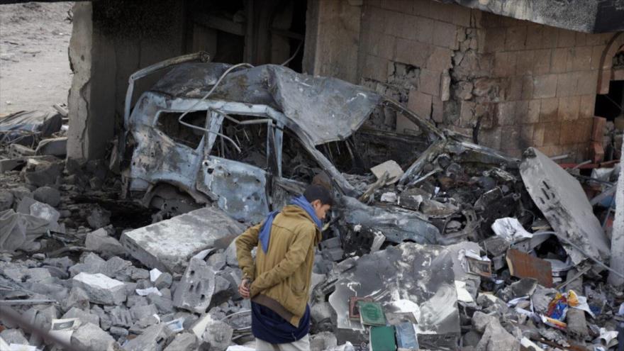 Un yemení inspecciona los escombros de un edificio destruido en los ataques aéreos de la coalición liderada por Arabia Saudí en Saná, 18 de enero de 2022.