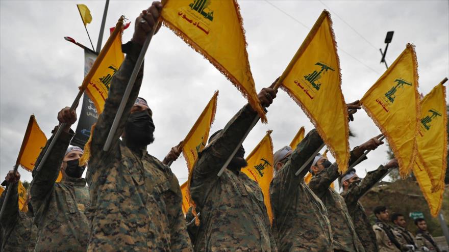 Combatientes de Hezbolá sostienen la bandera de este en una ceremonia en el sur de Beirut, capital de El Líbano, 4 de enero de 2022. (Foto: AP)