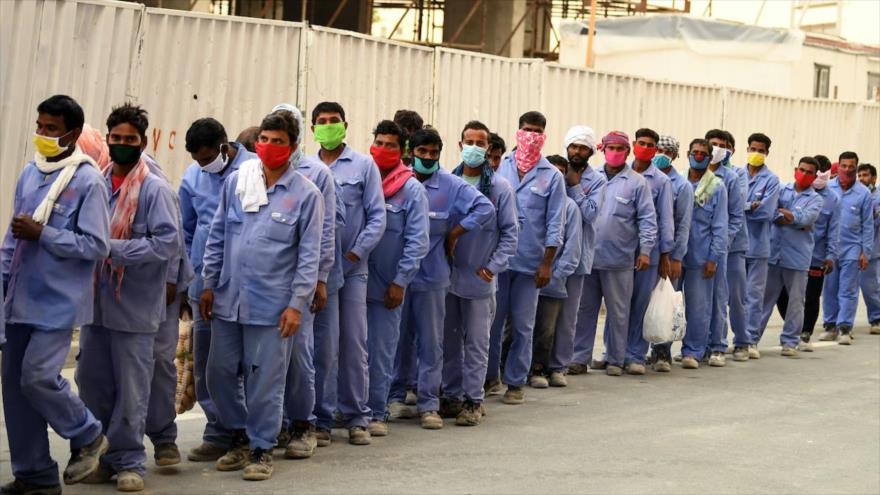 Trabajadores migrantes hacen fila para abordar un autobús que los transportará a su lugar de trabajo en Dubái, EAU, 2 de abril de 2020. (Foto: AFP)