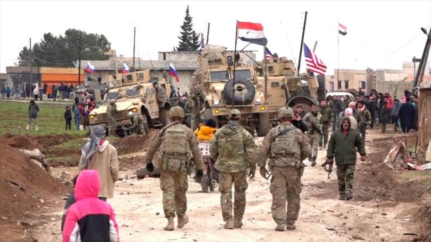 Fuerzas rusas y sirias al lado de un convoy militar de EE.UU. en la aldea de Jirbet, cerca de Al-Qamishli (noreste de siria), 12 de febrero de 2020.