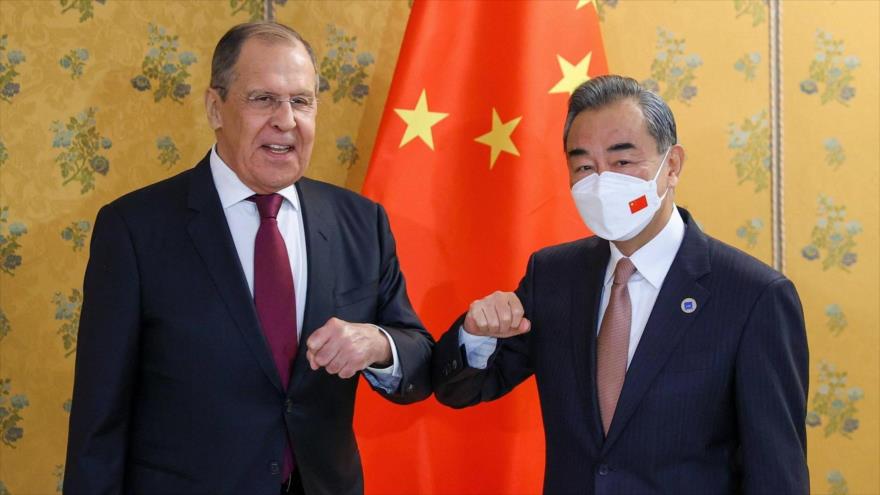 El ministro chino de Asuntos Exteriores, Wang Yi (dcha.), a su homólogo ruso, Serguéi Lavrov.