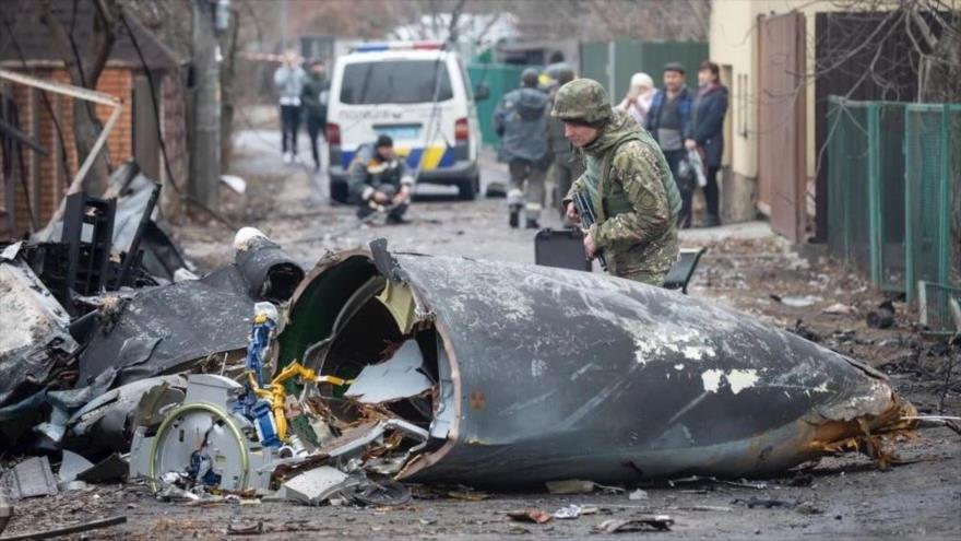 Soldado ucraniano inspecciona los restos de un avión derribado en Kiev, Ucrania, 25 de febrero de 2022.