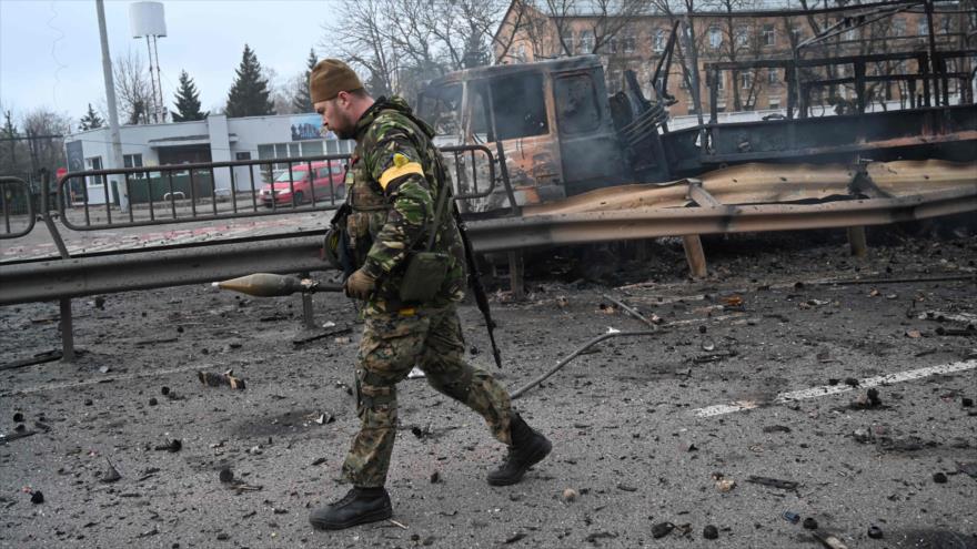 Soldado ucraniano recoge proyectiles sin explotar después de enfrentamiento con rusos en Kiev, capital ucraniana, 26 de febrero de 2022. (Foto: AFP)