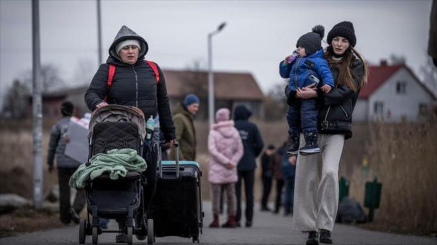 Refugiados de Ucrania atraviesan la frontera hacia Polonia.