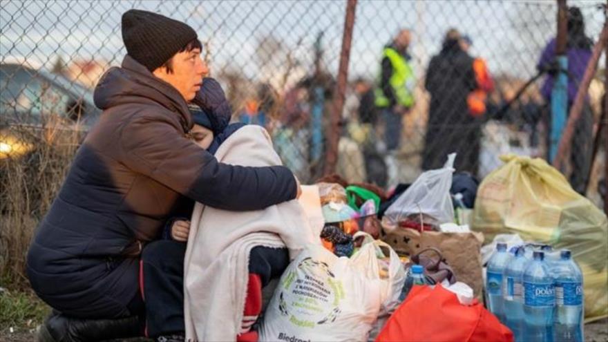 Una ciudadana ucraniana abraza a su hijo en la frontera de Ucrania con Polonia.