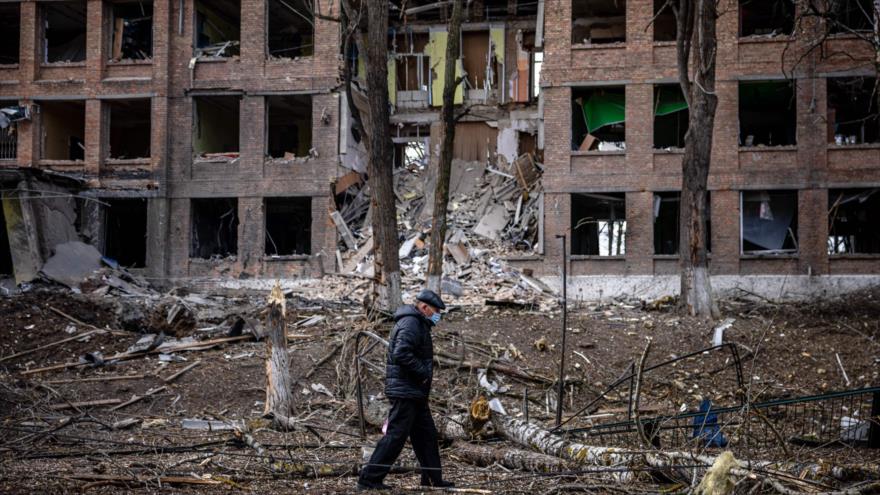 Un hombre camina frente a un edificio destruido tras un ataque de la operación militar especial rusa en Vasilkiv, 27 de febrero de 2022. (Foto: AFP)
