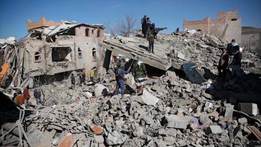 Yemeníes inspeccionan restos de edificios tras ataques aéreos de coalición saudí, en Saná, Yemen, 18 de enero de 2022. (Foto: AP)