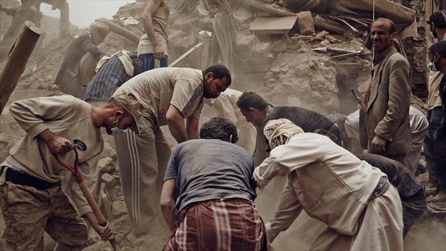 Ciudadanos yemeníes tratan de salvar a los sobrevivientes bajo escombros de un edificio destruido en un ataque aéreo saudí. 
