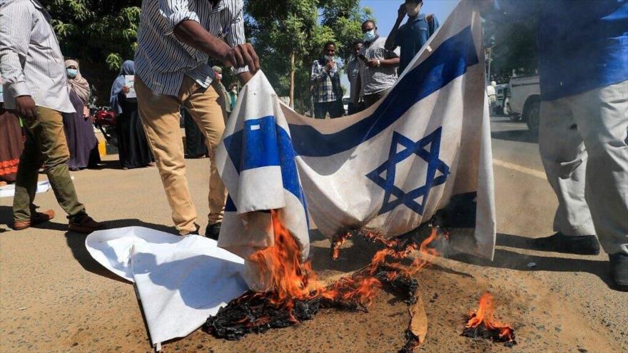 Sudaneses queman banderas israelíes durante una protesta contra normalización de lazos con Israel, Jartum, 17 de enero de 2021. (Foto: AFP)
