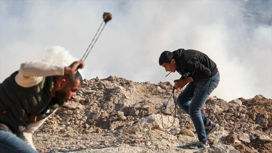 Manifestantes palestinos lanzan piedras contra fuerzas israelíes, Cisjordania, 7 de enero de 2022. (Foto: AFP)
