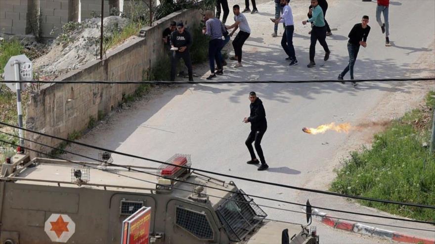 Palestinos lanzan cóctel molotov contra vehículo militar israelí en enfrentamientos en Yenin, Cisjordania ocupada, 9 de abril de 2022. (Foto: Getty Images)