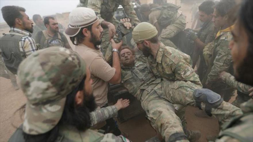 Combatientes rebeldes proturcos ayudan a su compañero herido cerca de la ciudad de Tal Abyad, en Siria, 24 de octubre de 2019. (Foto: Reuters)