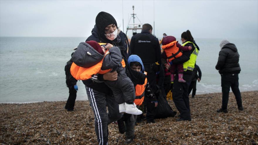 Una migrante rescatada con sus hijos llega a la costa británica de Kent tras cruzar el canal de la Mancha, 24 de noviembre de 2021. (Foto: AFP)