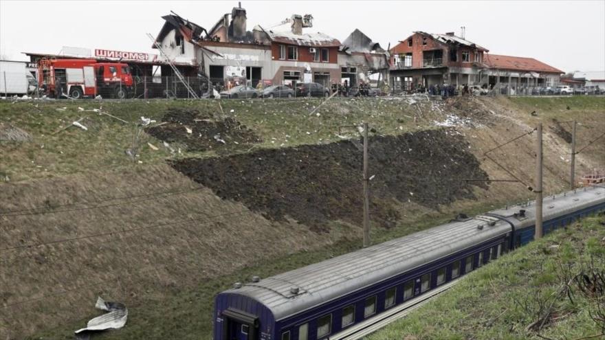 Vagones de tren circulan cerca de una instalación de servicio de automóviles dañada en operación rusa en Lviv, 18 de abril de 2022. (Foto: Getty Images)