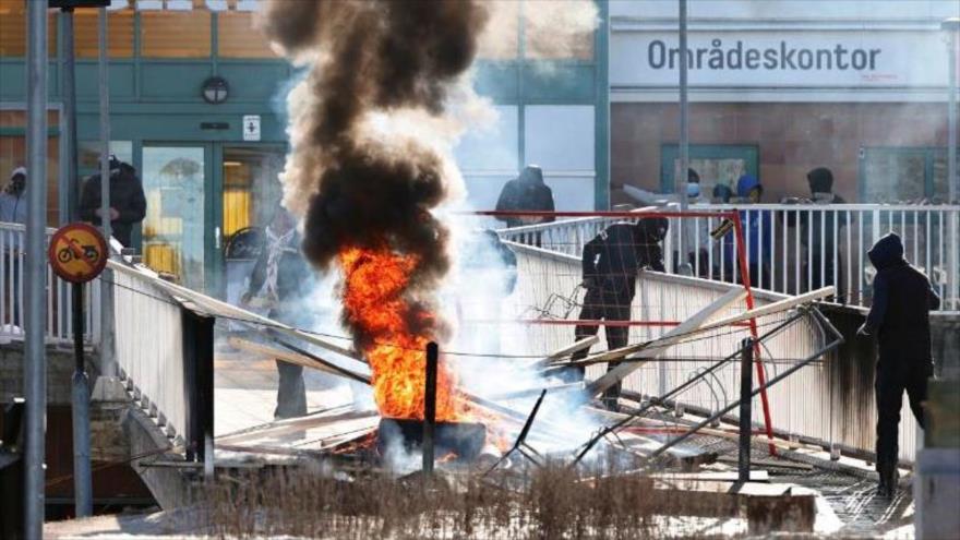 Manifestantes queman una barricada en la entrada de un centro comercial durante los choques en Linköping, Suecia, 17 de abril de 2022.