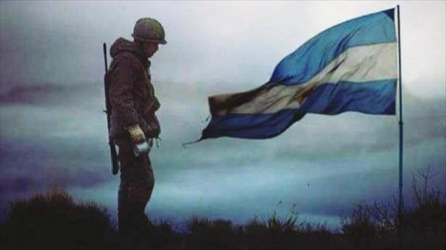 Un soldado junto a una bandera nacional argentina.