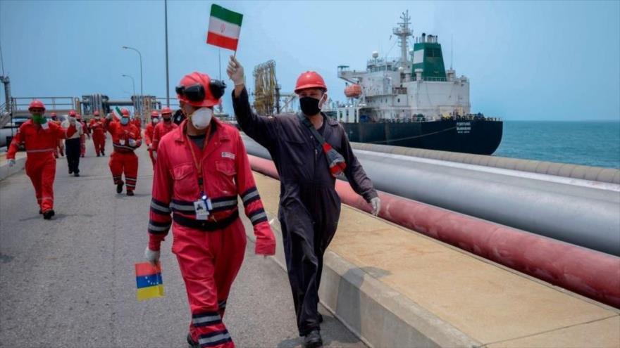 Un trabajador de la petrolera estatal venezolana PDVSA ondea una bandera iraní en el estado de Carabobo, Venezuela, 25 de mayo de 2020 (Foto: AFP)