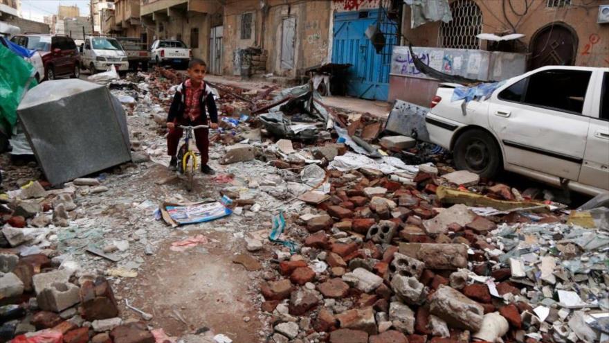 Un niño yemení anda en bicicleta sobre los escombros de casas destruidas en un ataque aéreo de la coalición saudí en Saná, Yemen. (Foto: Getty Images)