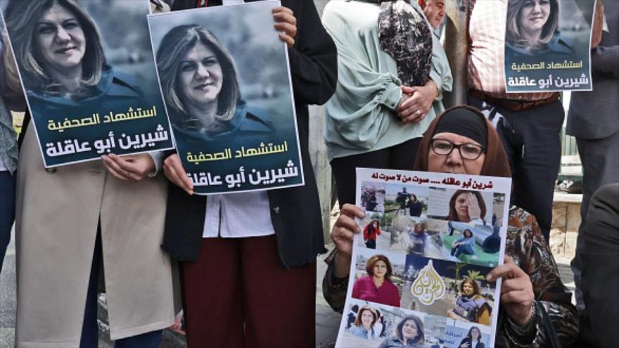 Palestinos portan imagen de la periodista asesinada Shireen Abu Akleh en la ciudad de Al-Jalil (Hebrón) en Cisjordania, 11 de mayo de 2022.