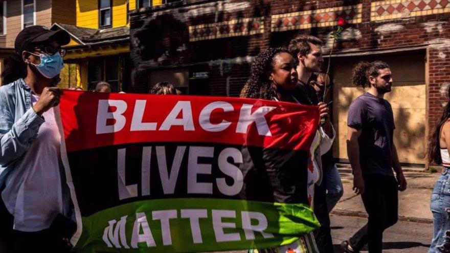 Los residentes de la ciudad estadounidense de Búfalo, en el estado de Nueva York, marchan con banderas y megáfonos sobre racismo en EE.UU., 15 de mayo de 2022.