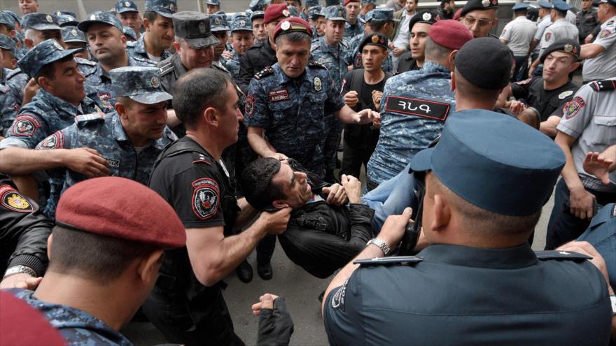 La Policía armenia detiene a manifestantes de la oposición que bloquean el edificio de la Cancillería en Ereván, 24 de mayo de 2022. 