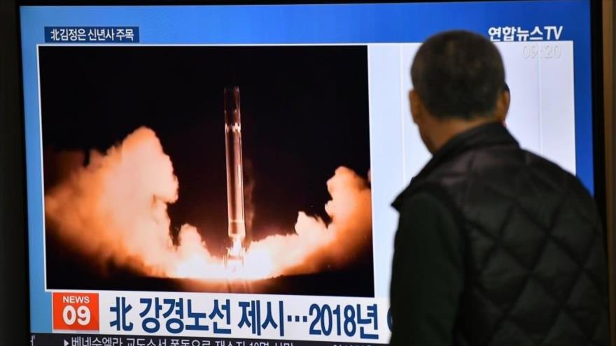 Un hombre mira un programa de noticias de televisión que muestra imágenes de archivo de la prueba de misiles de Corea del Norte, 1 de enero de 2020. (Foto: AFP)